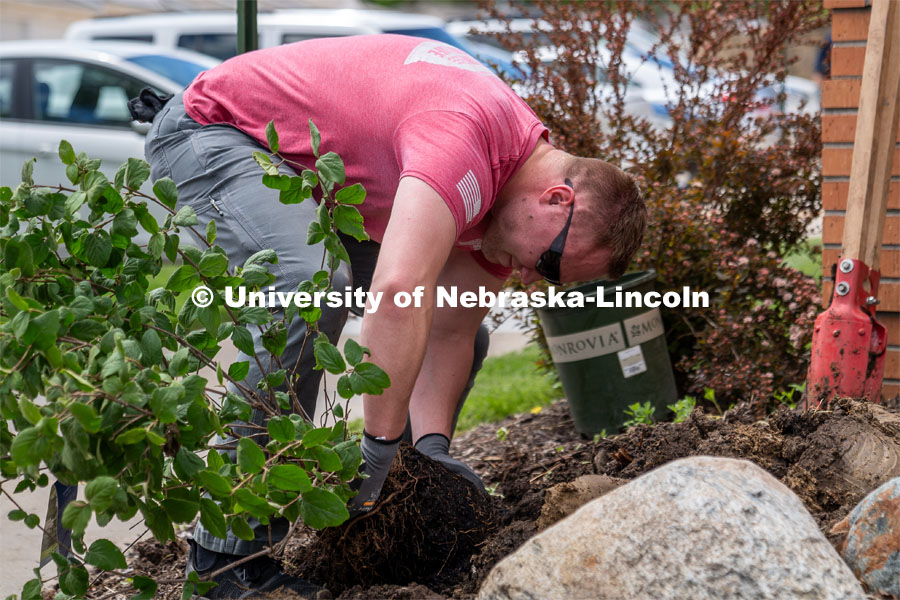 University of Nebraska-Lincoln student Preston Erks prepares to plant a shrub at the Van Dorn Villa Retirement Living complex during the Big Event. May 4,2024. Photo by Kirk Rangel for University Communication.